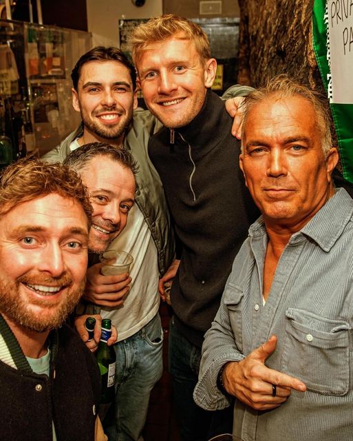 Friends grinning for the camera at the bar