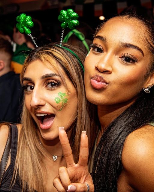 Two friends with shamrock headbands and face paint