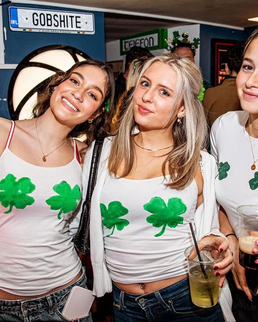 Friends in shamrock tops by the Gobshite sign
