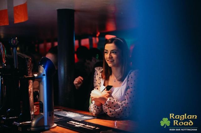 A guest smiling at the bar by the Guinness taps